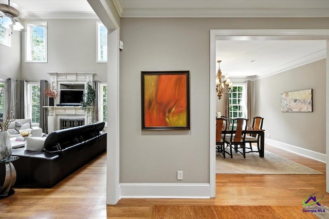 612 Remington Dr, Macon, GA 31210 - living area featuring a chandelier, a fireplace, wood finished floors, ornamental molding, and healthy amount of natural light