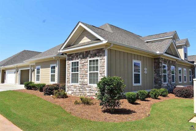 116 Sasanqua Dr, Warner Robins, GA 31088 - view of side of property featuring stone siding, an attached garage, concrete driveway, a shingled roof, and a lawn