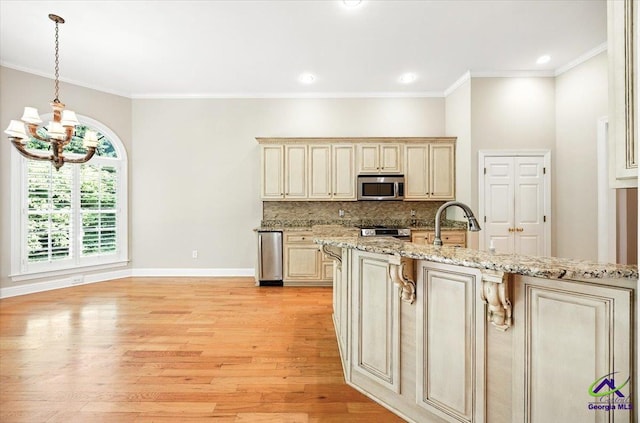 208 W Troon, Macon, GA 31210 - kitchen with appliances with stainless steel finishes, cream cabinetry, a chandelier, light wood-style floors, and decorative backsplash