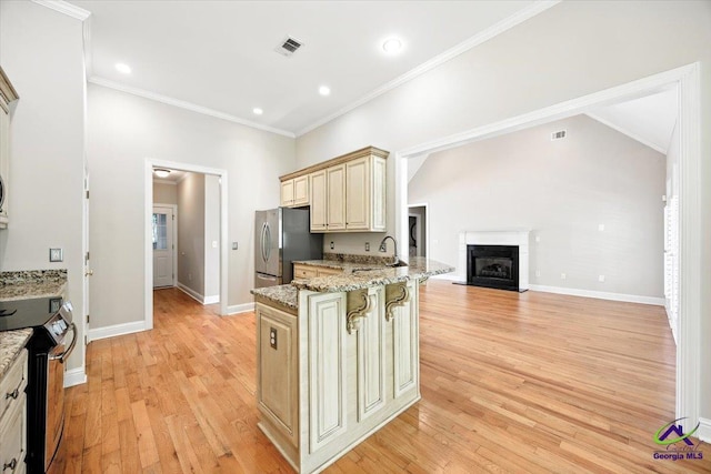 208 W Troon, Macon, GA 31210 - kitchen with stainless steel appliances, cream cabinets, a kitchen breakfast bar, light wood finished floors, and ornamental molding