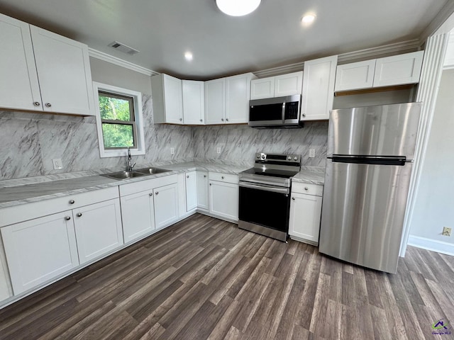 1930 Northbrook Ave, Macon, GA 31204 - kitchen with stainless steel appliances, dark wood-type flooring, white cabinets, light stone countertops, and ornamental molding