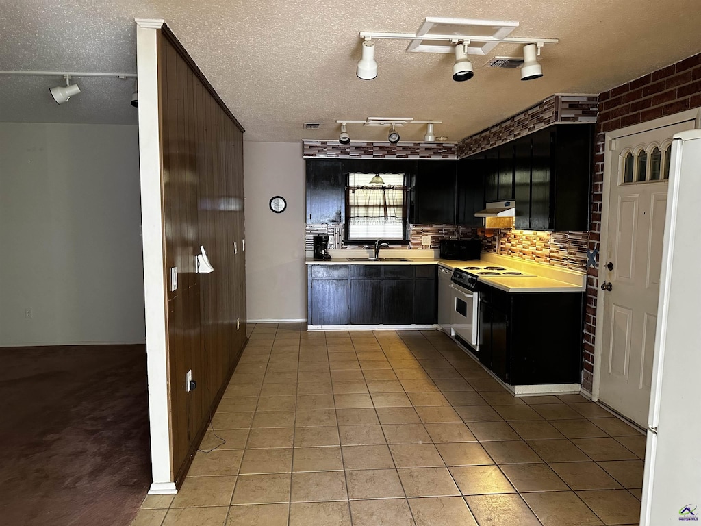 108 Virginia Dr, Warner Robins, GA 31093 - kitchen with electric stove, light countertops, dark cabinetry, light tile patterned floors, and a textured ceiling