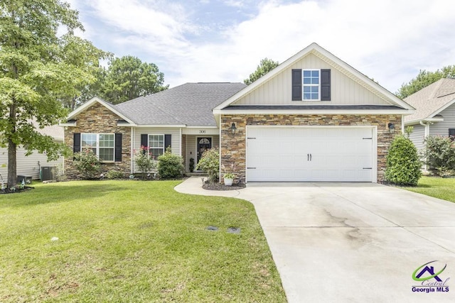 306 Gibson Cir, Kathleen, GA 31047 - craftsman-style home with stone siding, a front yard, driveway, board and batten siding, and a garage