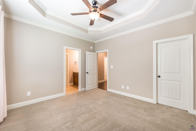 301 Vinings Place Dr, Warner Robins, GA 31088 - unfurnished bedroom featuring a tray ceiling, crown molding, light carpet, ensuite bathroom, and ceiling fan