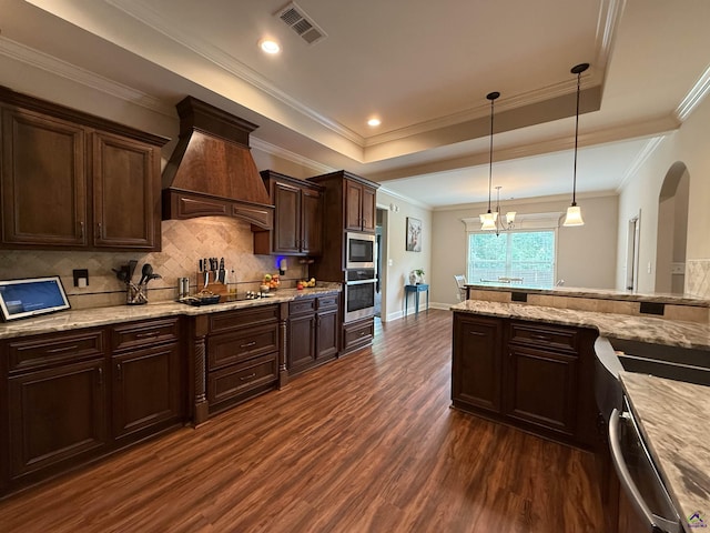 240 Woodlands Blvd, Kathleen, GA 31047 - kitchen with custom range hood, stainless steel appliances, dark wood-style floors, a raised ceiling, and dark brown cabinets