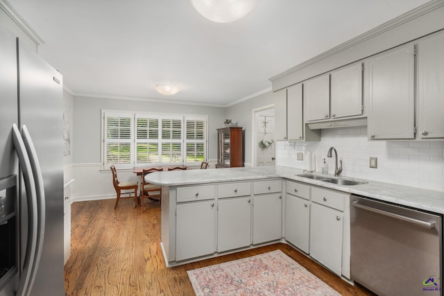 4871 Oxford Rd, Macon, GA 31210 - kitchen featuring stainless steel appliances, ornamental molding, a peninsula, light countertops, and wood finished floors
