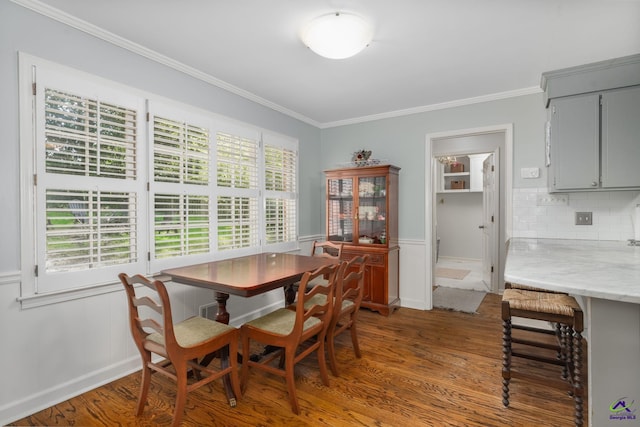 4871 Oxford Rd, Macon, GA 31210 - dining space featuring wood finished floors, ornamental molding, a wainscoted wall, and a decorative wall