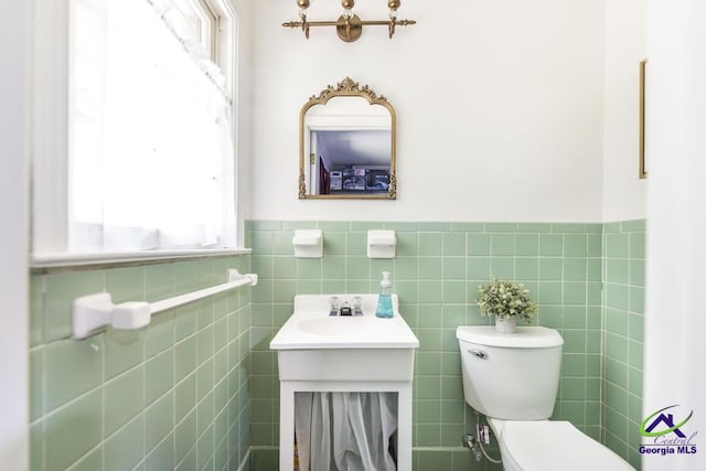2740 Riverview Rd, Macon, GA 31204 - half bath with healthy amount of natural light, vanity, tile walls, and wainscoting