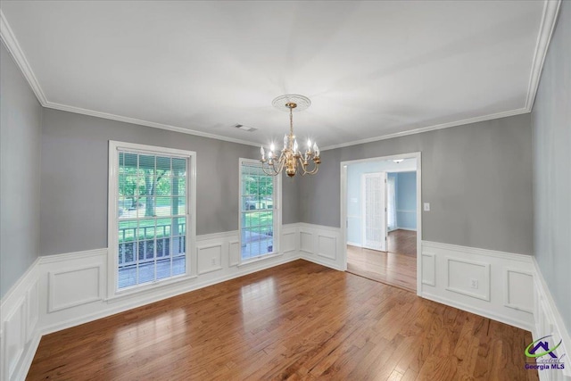 105 International Blvd, Warner Robins, GA 31088 - spare room featuring a chandelier, wainscoting, crown molding, wood finished floors, and a decorative wall