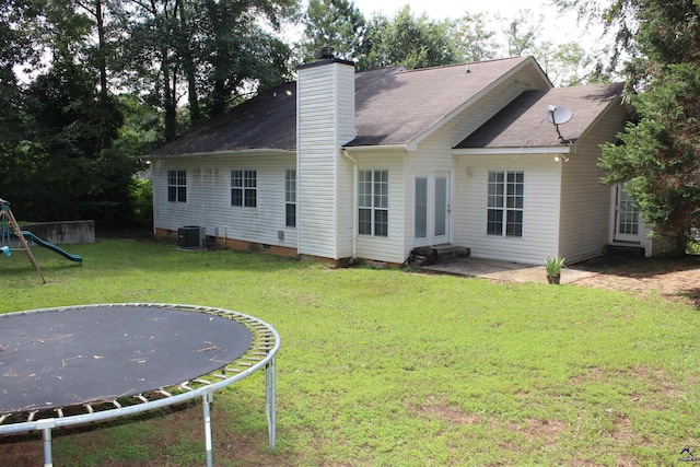 125 Buckskin Trl, Byron, GA 31008 - back of property with a trampoline, a yard, a chimney, a patio area, and crawl space