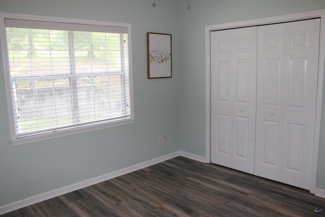 125 Buckskin Trl, Byron, GA 31008 - unfurnished bedroom featuring dark wood-style floors, a closet, and multiple windows