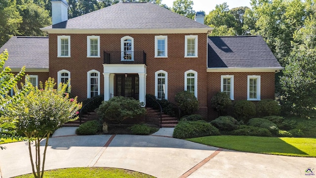 228 Lagrange Ct, Macon, GA 31210 - colonial-style house featuring a chimney, a shingled roof, brick siding, and a balcony
