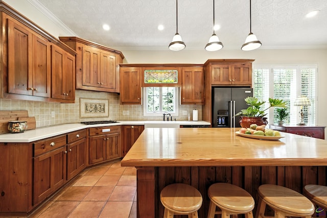 228 Lagrange Ct, Macon, GA 31210 - kitchen featuring high end refrigerator, a textured ceiling, brown cabinets, tasteful backsplash, and crown molding