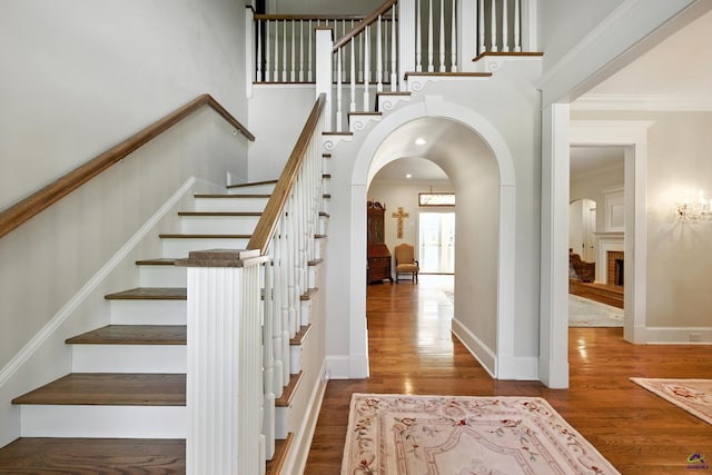 228 Lagrange Ct, Macon, GA 31210 - stairway with arched walkways, wood finished floors, crown molding, and a towering ceiling