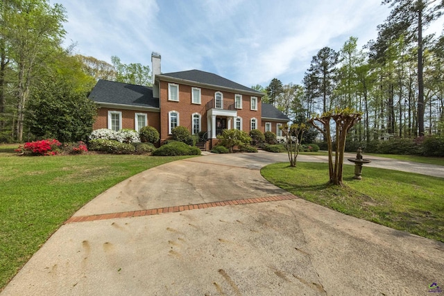 228 Lagrange Ct, Macon, GA 31210 - view of front of house featuring brick siding, curved driveway, a chimney, and a front lawn