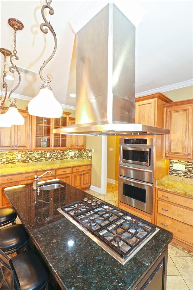 kitchen with light tile flooring, sink, island exhaust hood, and tasteful backsplash