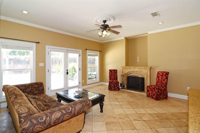 living room with ceiling fan, ornamental molding, plenty of natural light, and light tile floors