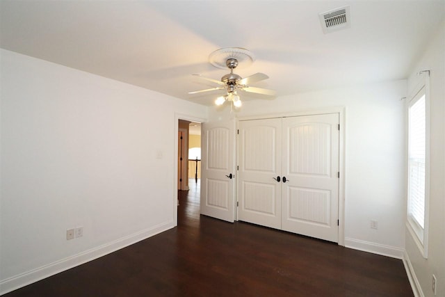 unfurnished bedroom featuring a closet, ceiling fan, and dark hardwood / wood-style flooring