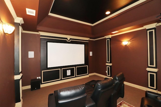 carpeted cinema room featuring crown molding, decorative columns, and a tray ceiling