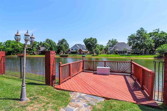 deck featuring a water view and a lawn