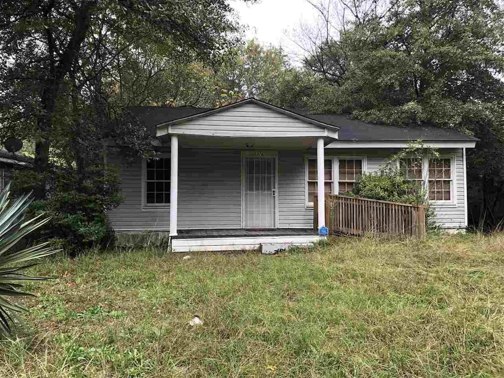 view of outdoor structure with a porch and a lawn