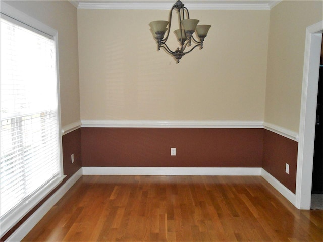 empty room featuring plenty of natural light, a chandelier, and dark hardwood / wood-style flooring