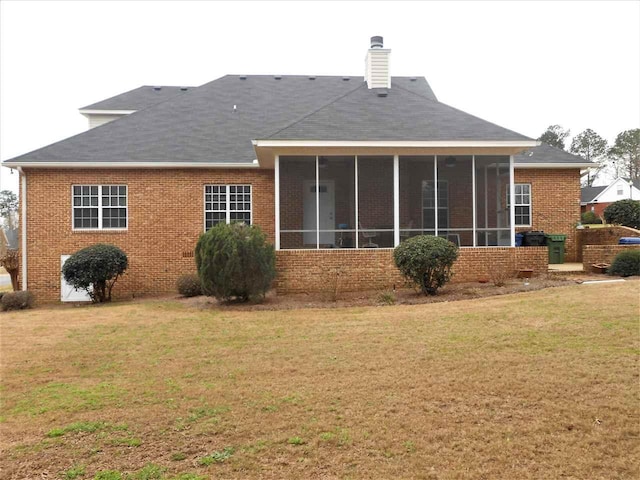 rear view of property with a sunroom and a lawn