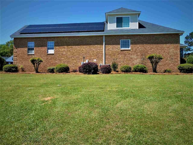 view of property exterior with solar panels and a yard