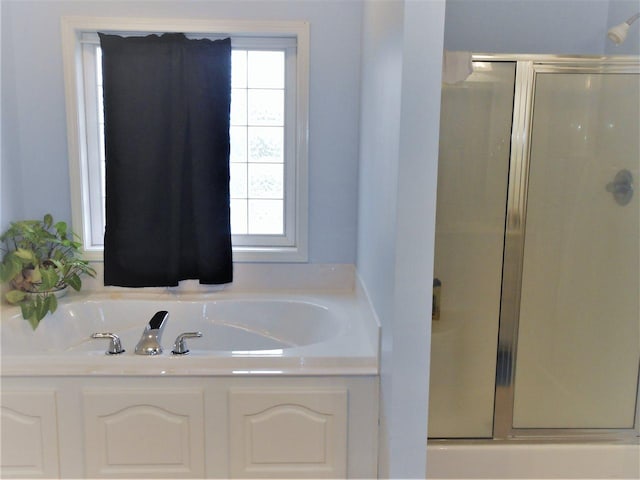 bathroom featuring a wealth of natural light and separate shower and tub