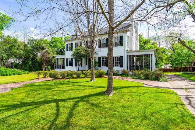 colonial-style house featuring a front lawn