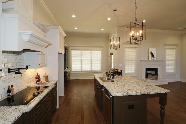 kitchen featuring an inviting chandelier, tasteful backsplash, ornamental molding, dark hardwood / wood-style flooring, and light stone counters