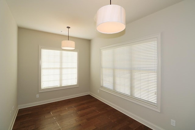 unfurnished room featuring a healthy amount of sunlight and dark hardwood / wood-style flooring