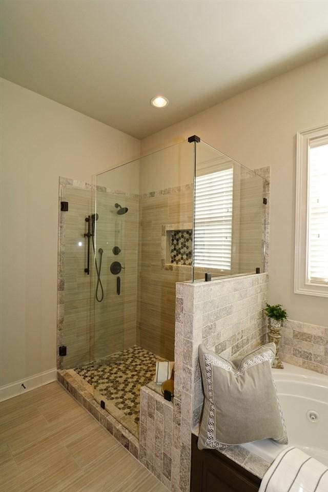 bathroom featuring shower with separate bathtub and tile floors