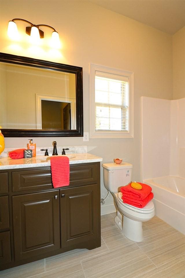 full bathroom featuring bathtub / shower combination, tile floors, toilet, and vanity