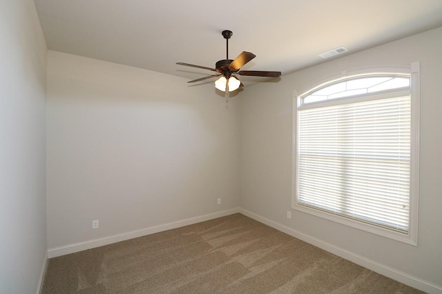 carpeted spare room featuring ceiling fan