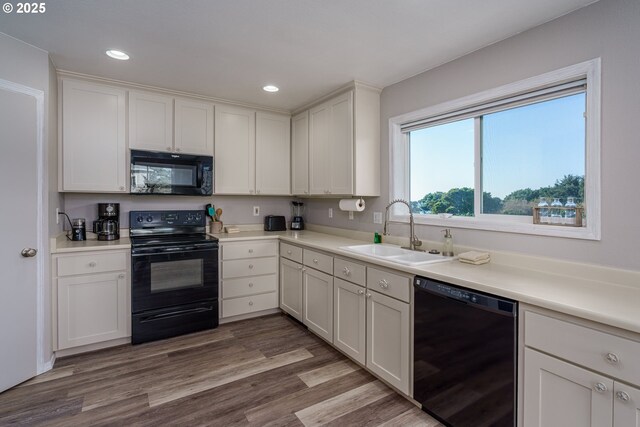 2131 Beach Loop Dr, Bandon, OR 97411 - kitchen featuring black appliances, a sink, wood finished floors, white cabinetry, and recessed lighting