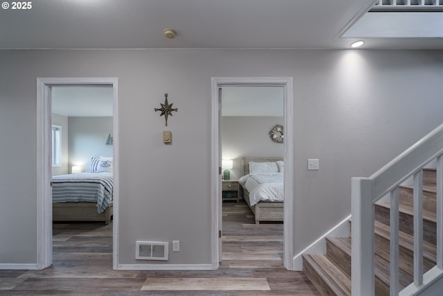 2131 Beach Loop Dr, Bandon, OR 97411 - hall with visible vents, baseboards, wood finished floors, and stairway