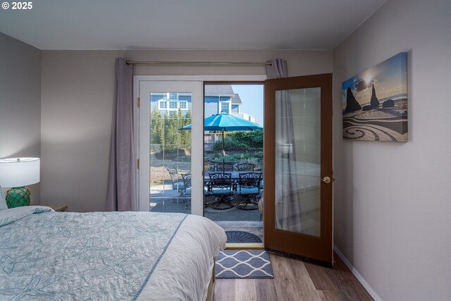 2131 Beach Loop Dr, Bandon, OR 97411 - bedroom with access to exterior, french doors, baseboards, and wood finished floors