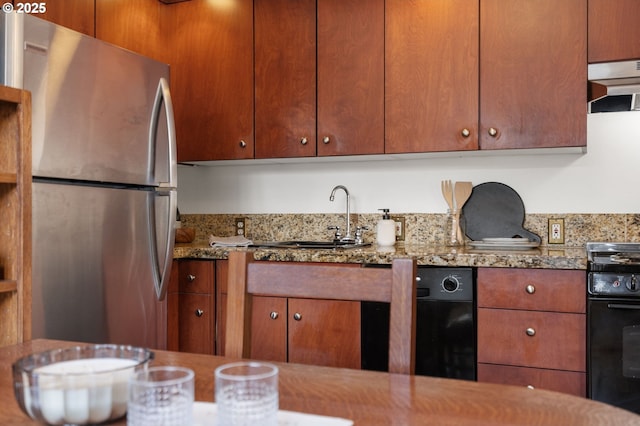 kitchen with oven, a sink, freestanding refrigerator, ventilation hood, and light stone countertops