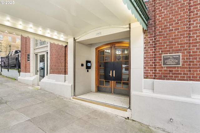 entrance to property featuring brick siding