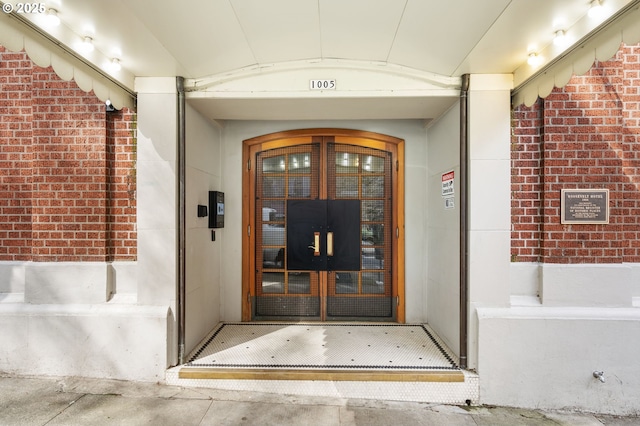view of exterior entry with brick siding