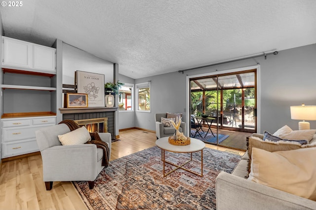 602 SE 130th Ct, Vancouver, WA 98683 - living area featuring a textured ceiling, light wood-style flooring, a brick fireplace, and lofted ceiling