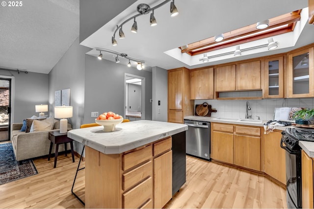 602 SE 130th Ct, Vancouver, WA 98683 - kitchen featuring stainless steel dishwasher, a sink, light wood-style flooring, backsplash, and black range oven