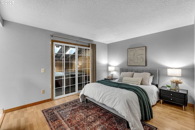 602 SE 130th Ct, Vancouver, WA 98683 - bedroom with access to outside, wood finished floors, baseboards, and a textured ceiling