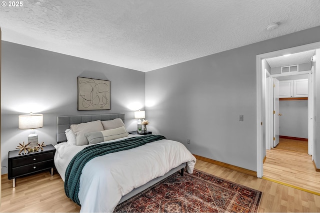 602 SE 130th Ct, Vancouver, WA 98683 - bedroom with a textured ceiling, light wood finished floors, and baseboards
