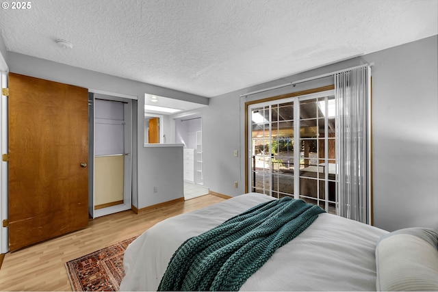 602 SE 130th Ct, Vancouver, WA 98683 - bedroom with access to exterior, a textured ceiling, light wood finished floors, and baseboards