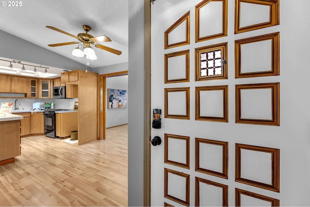602 SE 130th Ct, Vancouver, WA 98683 - kitchen with black range oven, stainless steel microwave, a sink, a ceiling fan, and light countertops