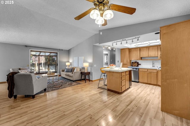 602 SE 130th Ct, Vancouver, WA 98683 - kitchen featuring open floor plan, dishwasher, light wood-type flooring, a sink, and vaulted ceiling
