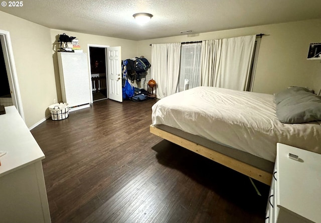 bedroom featuring dark wood-type flooring and a textured ceiling