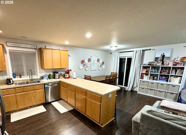 kitchen featuring dishwasher, a peninsula, a sink, and dark wood finished floors